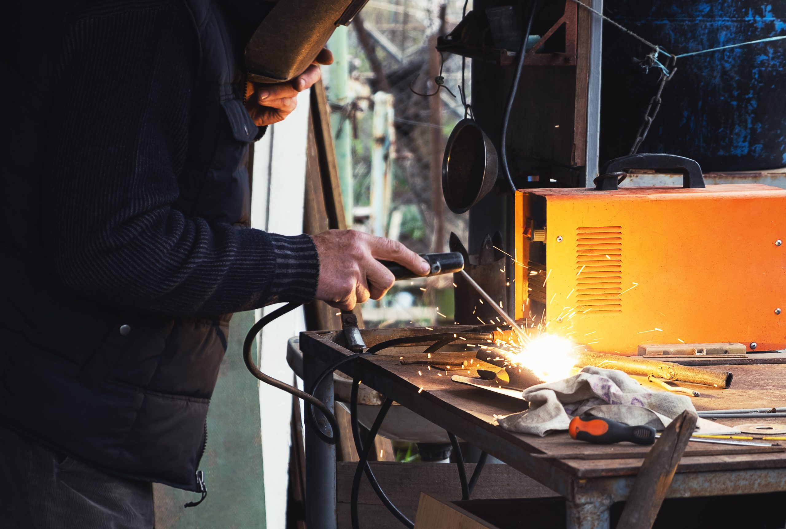 Man welding old shovel, close up